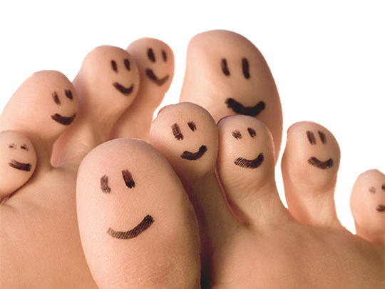happy feet - toes with smiley faces drawn on them.